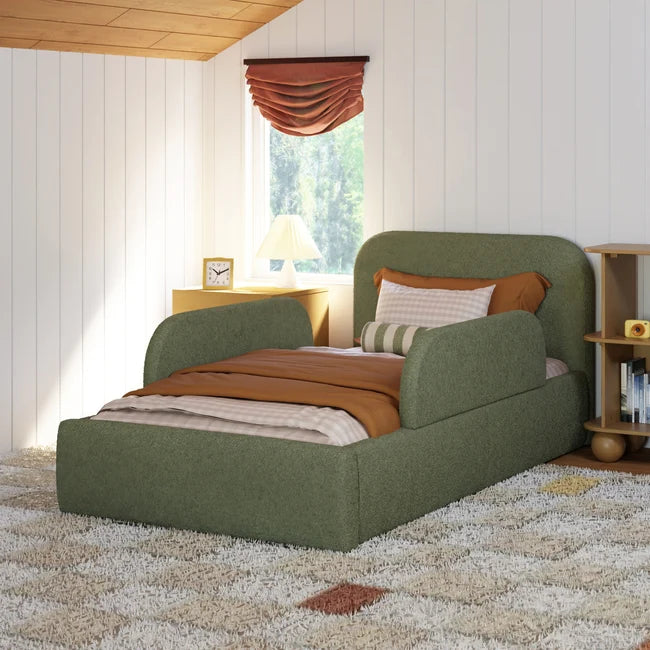 Green upholstered bed in a bedroom with a window and bookshelf.