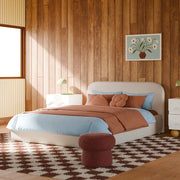 Modern bedroom with wooden walls, a bed with blue and brown bedding, and a decorative rug.