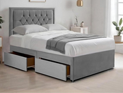 Gray upholstered bed with storage drawers in a bedroom setting