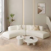 Modern living room with a white sectional sofa, coffee table, and decorative items.