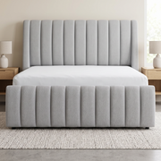 Bliss Channel-Tufted Upholstered Bed shown in light grey fabric in a bright bedroom – illustrative image – Dune & Pine