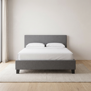 Noor Premium Bed Frame shown in charcoal grey fabric in a bright bedroom – illustrative image – Dune & Pine