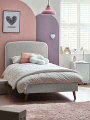 Children's bedroom with a gray bed, pink walls, and decorative elements.