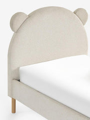 Beige bed with bear ear headboard on a white background