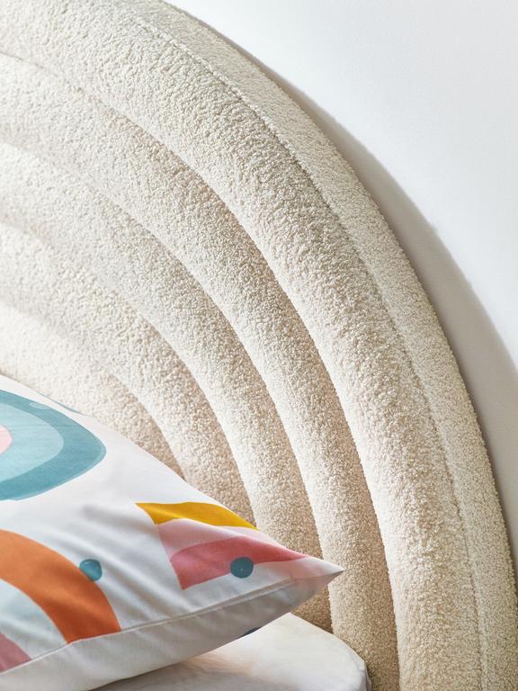 Decorative pillow with colorful design on a textured wall