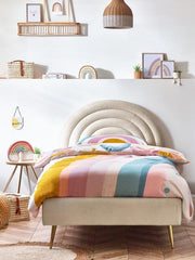 Bed with colorful striped bedding in a bright bedroom
