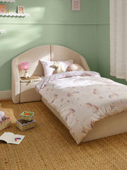 Children's bedroom with a bed featuring unicorn-themed bedding and decor.
