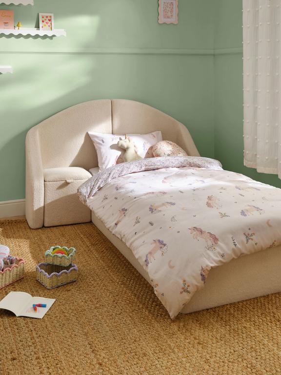 Children's bedroom with a bed featuring a floral comforter and unicorn design.