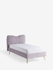 Purple bed with bow-shaped headboard on a white background
